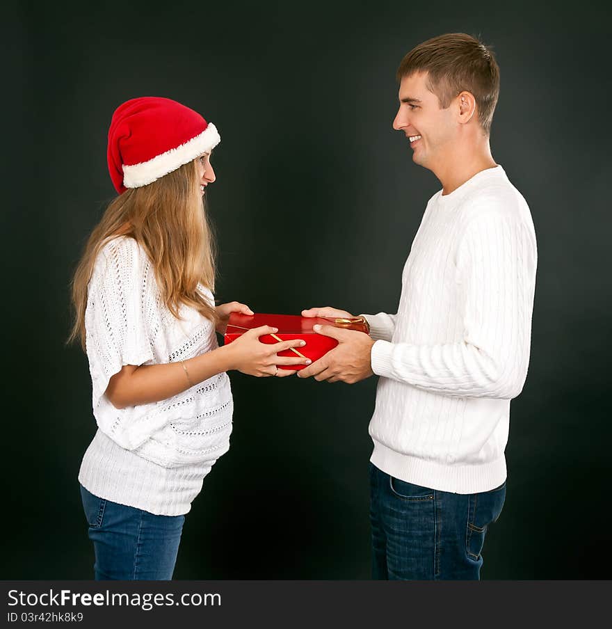 The man gives the gift pregnant girl in Santa hat