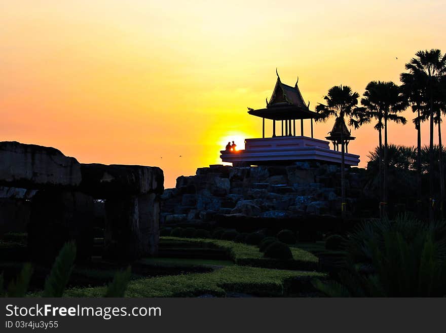 A familly take a rest on the pavilios by sunset at the stone henge in Nong Nooch Tropical Garden Thailand