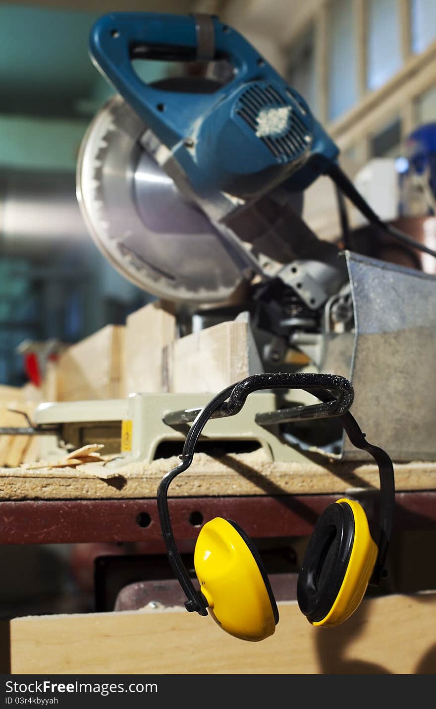 Plywood circular saw and protective earphones