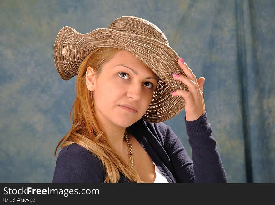 Girl with a summer hat on a blue background. Girl with a summer hat on a blue background