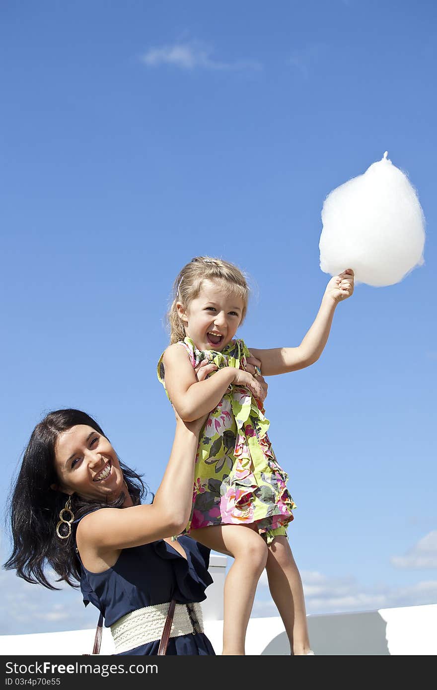 Happy and smiling mum and daughter with candy-floss. Happy and smiling mum and daughter with candy-floss