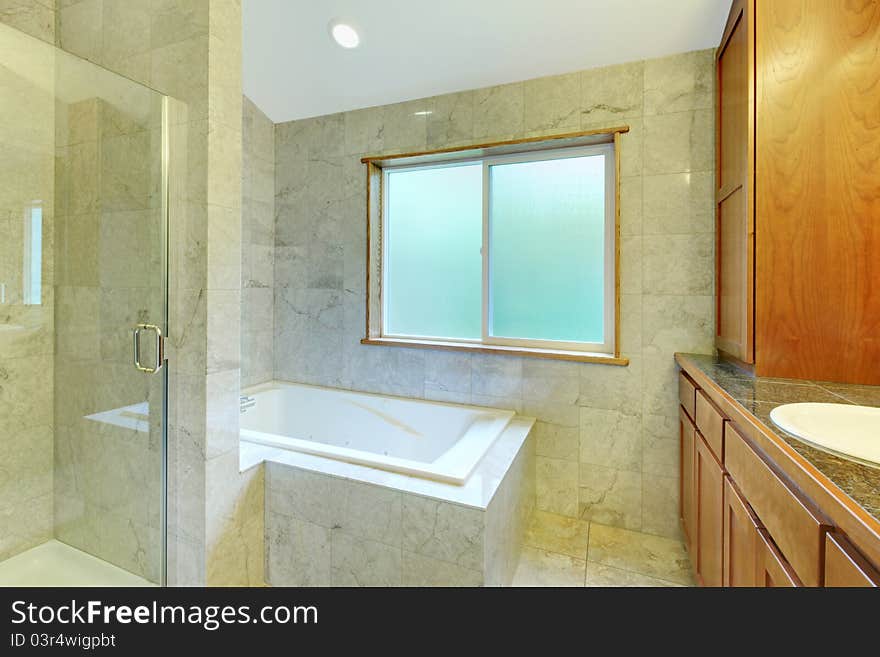 White Tub With Large Window And Tiles.