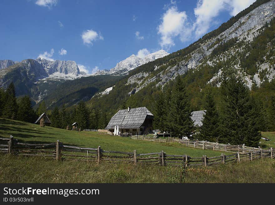 Rural Wooden fence with Green Grass, house and Blue Skies. Rural Wooden fence with Green Grass, house and Blue Skies