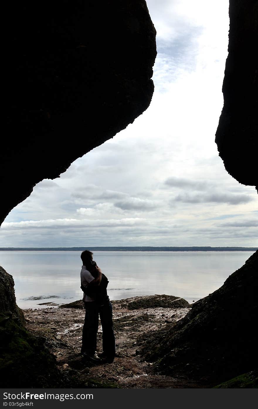 Couple Hugging in Hopewell Rock ocean floor, Nova Scotia, Canada. The Hopewell Rocks is located along the coast of the Bay of Fundy, which is home to the world’s highest tides. A deep hug means their love forever just like the high tide and low tide every day.