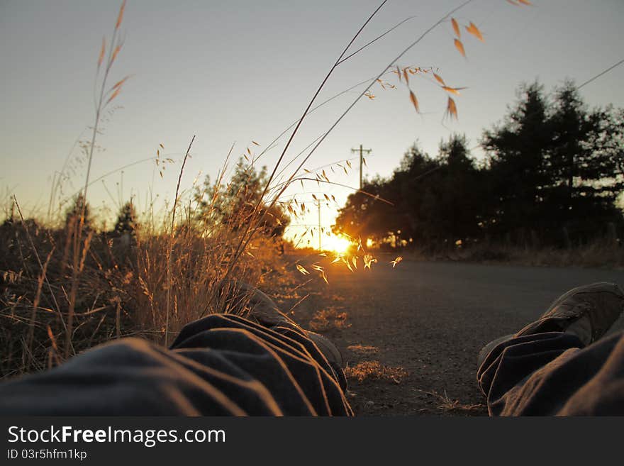 At dusk a beam lights up a young mans point of view of the road and field. Summer time sensations. At dusk a beam lights up a young mans point of view of the road and field. Summer time sensations.