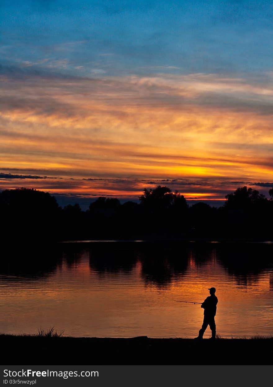 Fisherman at sunset in the orange and blue colors