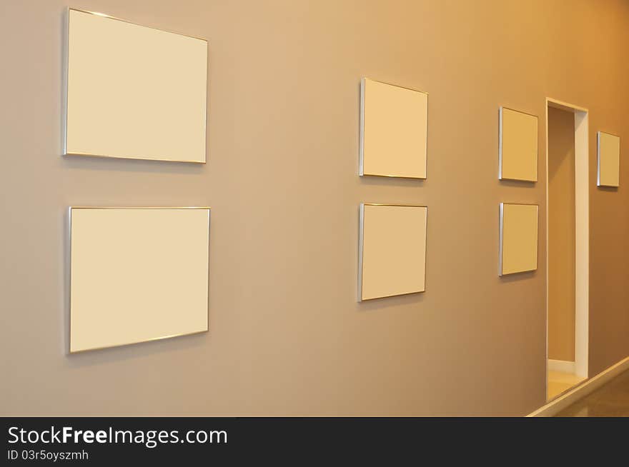 Frames decorated on wall in tungsten light.