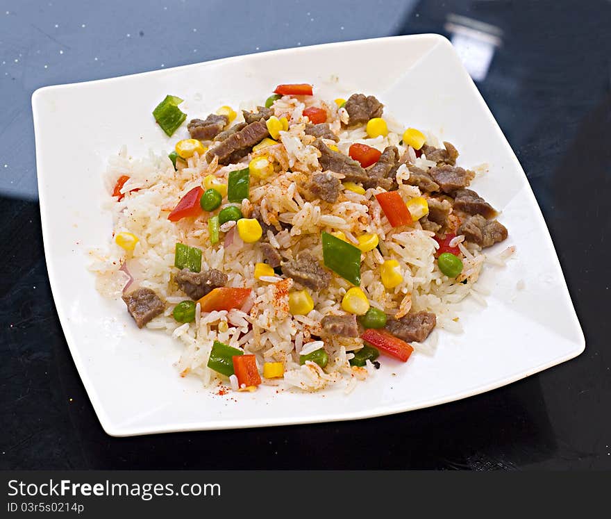 Beef, peas fried rice on a plate