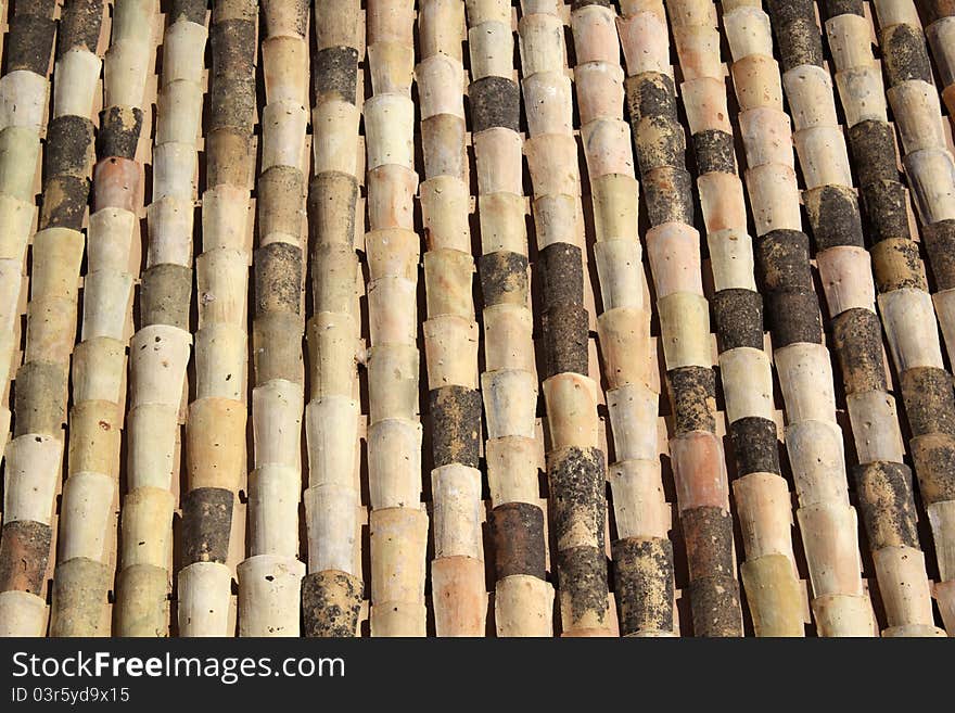 Ceramic terracotta roof tiles covering a Sicilian roof in rows. Ceramic terracotta roof tiles covering a Sicilian roof in rows