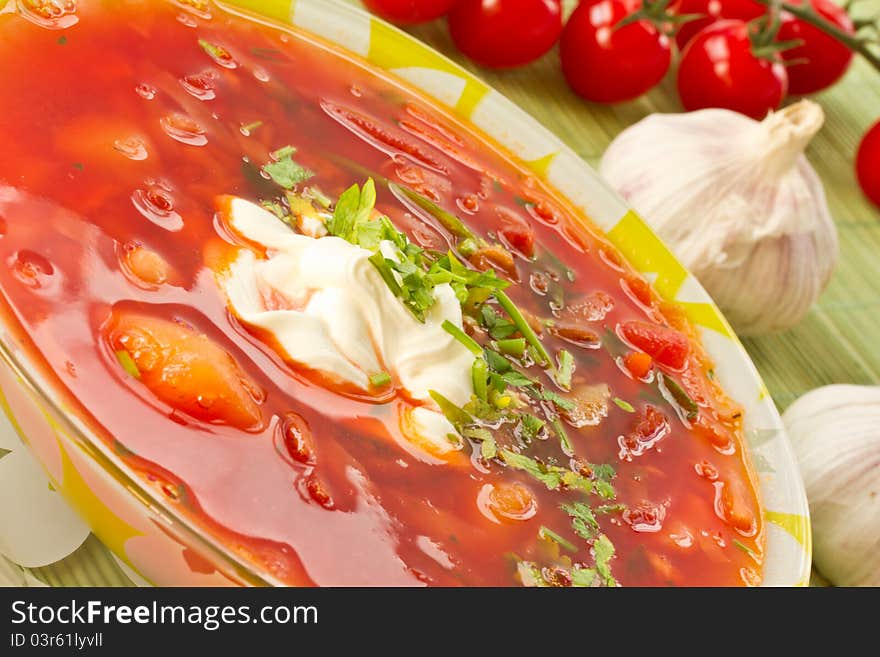 Fresh hot beet borscht with sour cream and herbs