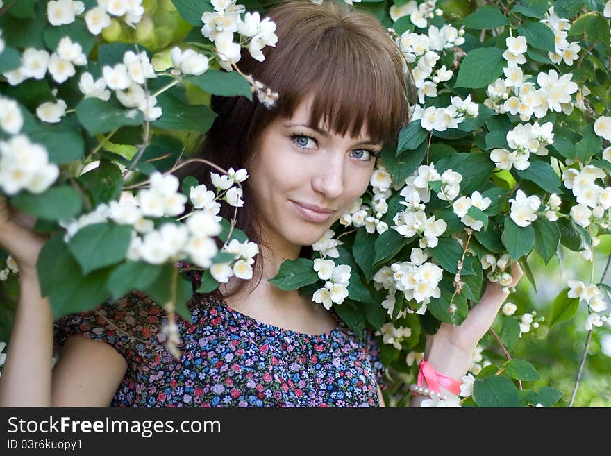 Smiling Girl Standing Among Flowers