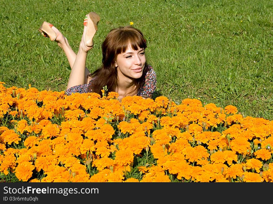 Beautiful girl lying on meadow with flowers