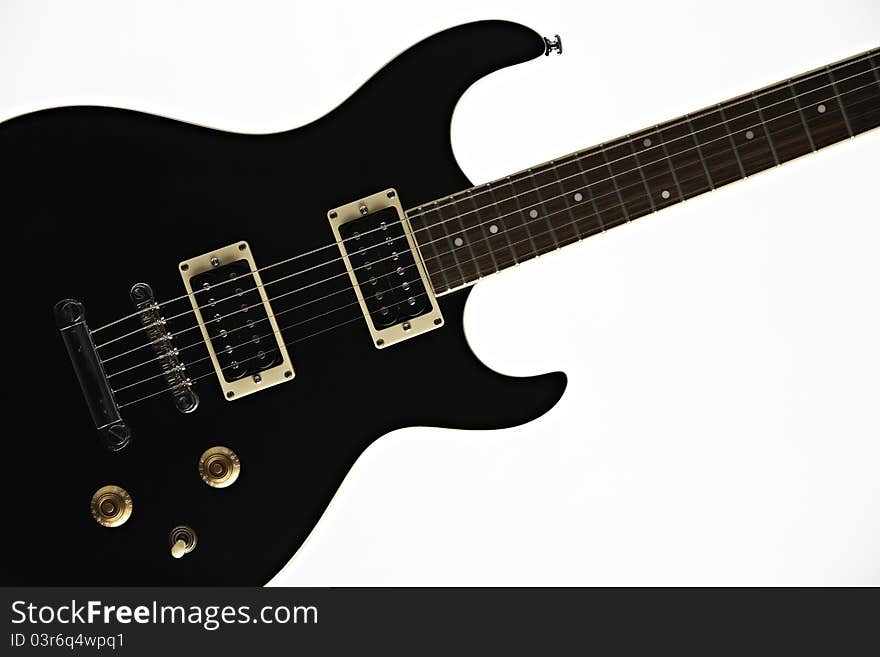 A black electric guitar isolated against a white background. A black electric guitar isolated against a white background