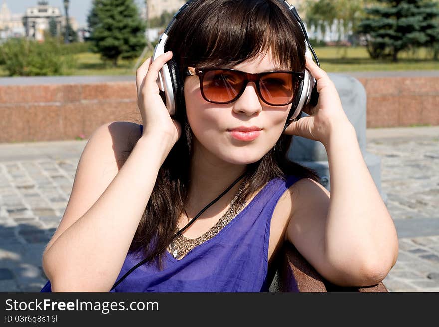 Girl listening music in headphones in park