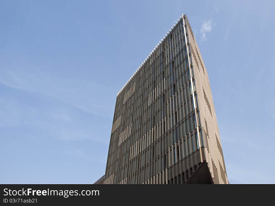 A Triangular Cream and Brown Office Block under a blue sky