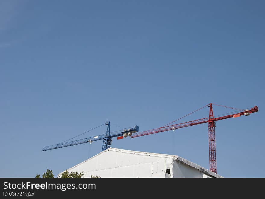 Red and Blue Tower Cranes against a blue sky