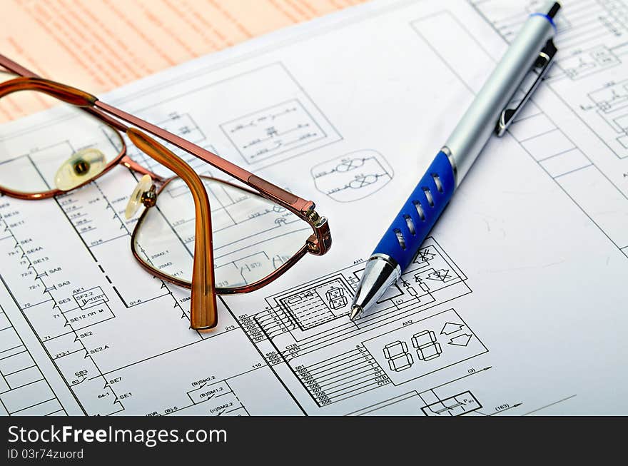 The electric scheme and pen on a table