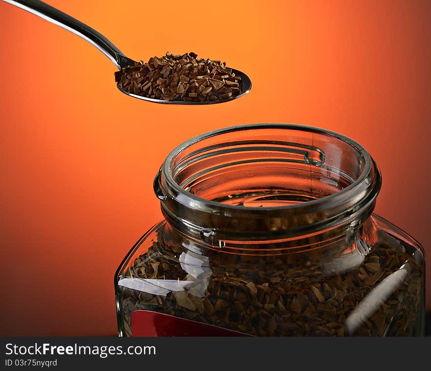 Spoon with instant coffee on a dark red background