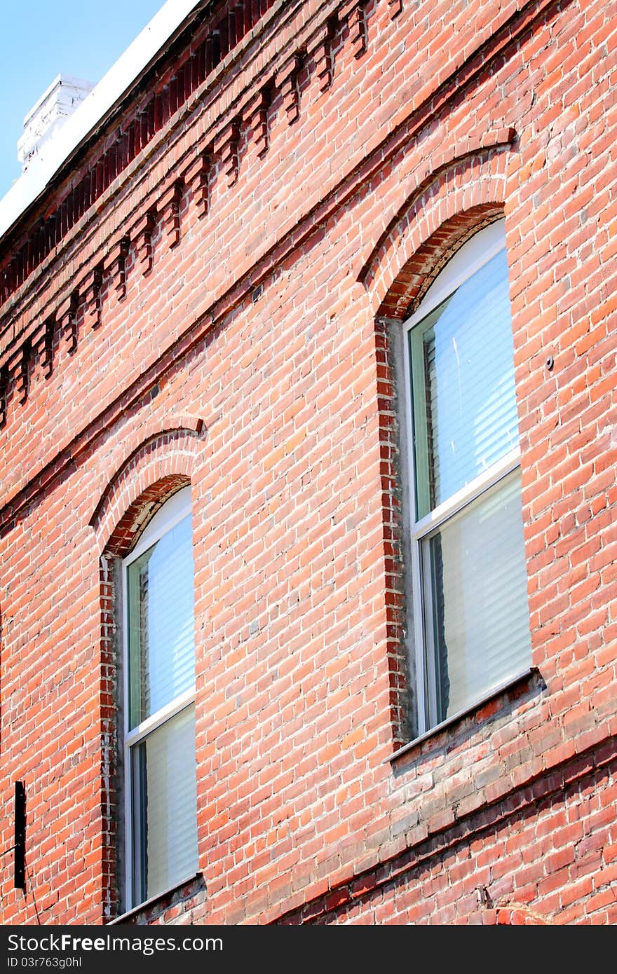 A view of the details of an old brick wall with windows. A view of the details of an old brick wall with windows.