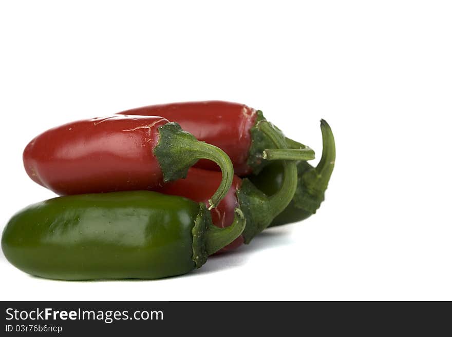 Red and green jalapeno peppers on a white background