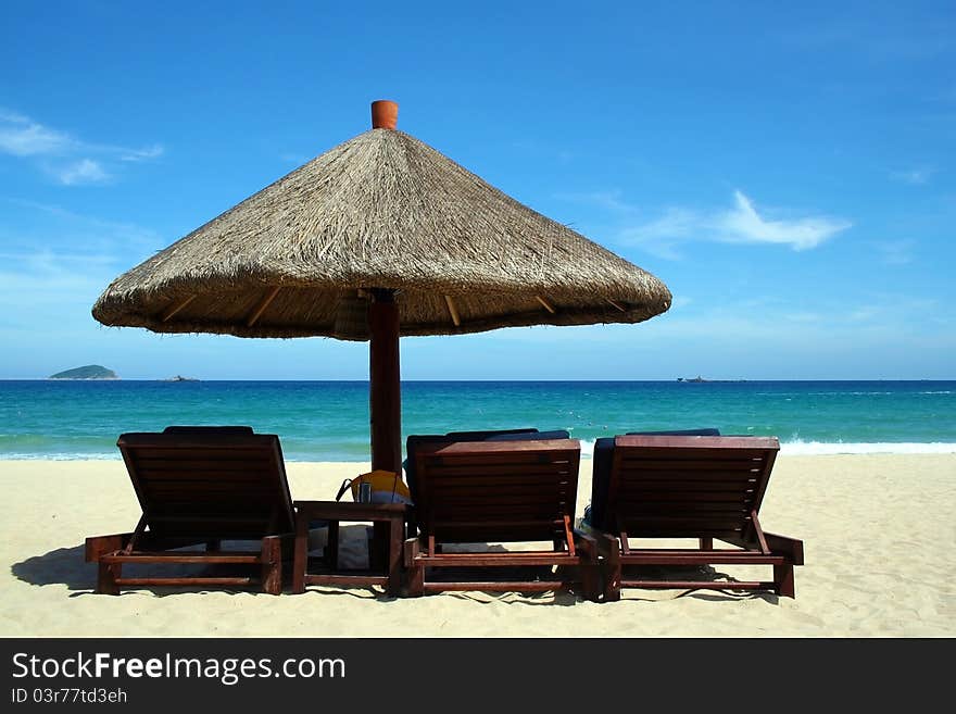 An attractive view of a beach with chairs and sun umbrella. An attractive view of a beach with chairs and sun umbrella.