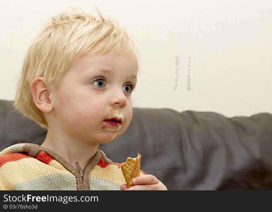 Cute blond toddler boy enjoying an ice cream. Cute blond toddler boy enjoying an ice cream