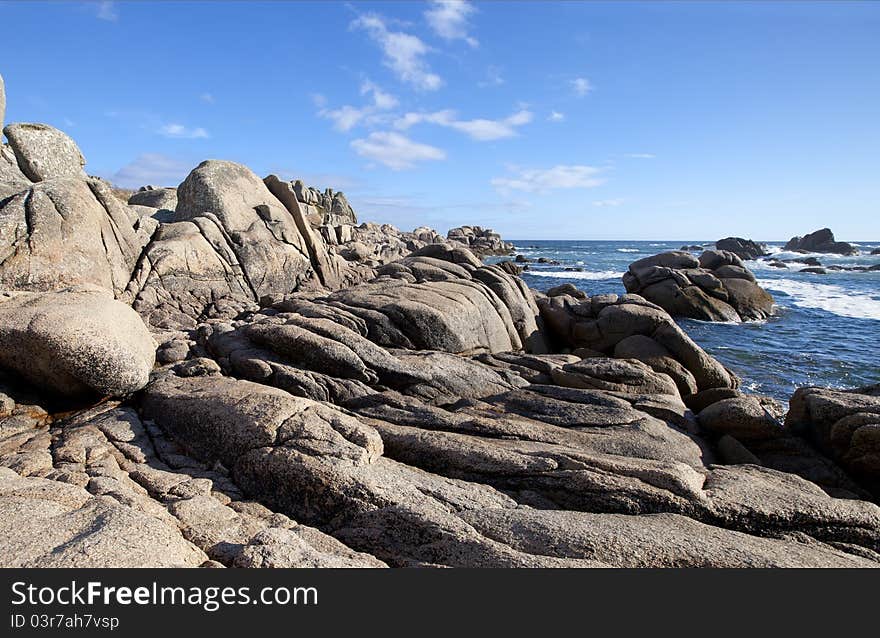 Ocean stone coast and blue sky in Galicia