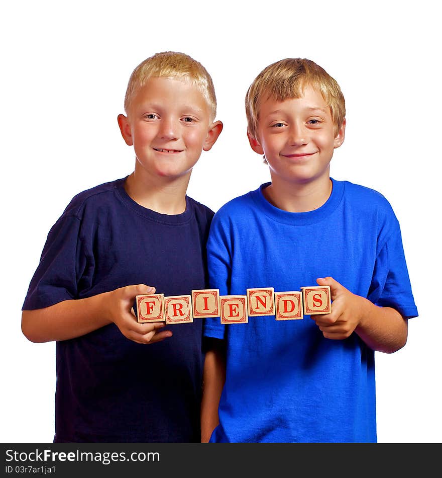 Two young boys who are friends holding letter wood blocks spelling Friends. Two young boys who are friends holding letter wood blocks spelling Friends.