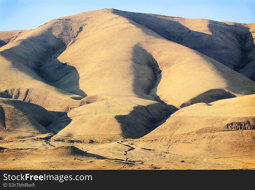 Sun and shadows on grasses that grow on the rolling golden hills that look like velvet. Located in Eastern Washington along the Columbia River under clear blue skies. Sun and shadows on grasses that grow on the rolling golden hills that look like velvet. Located in Eastern Washington along the Columbia River under clear blue skies.