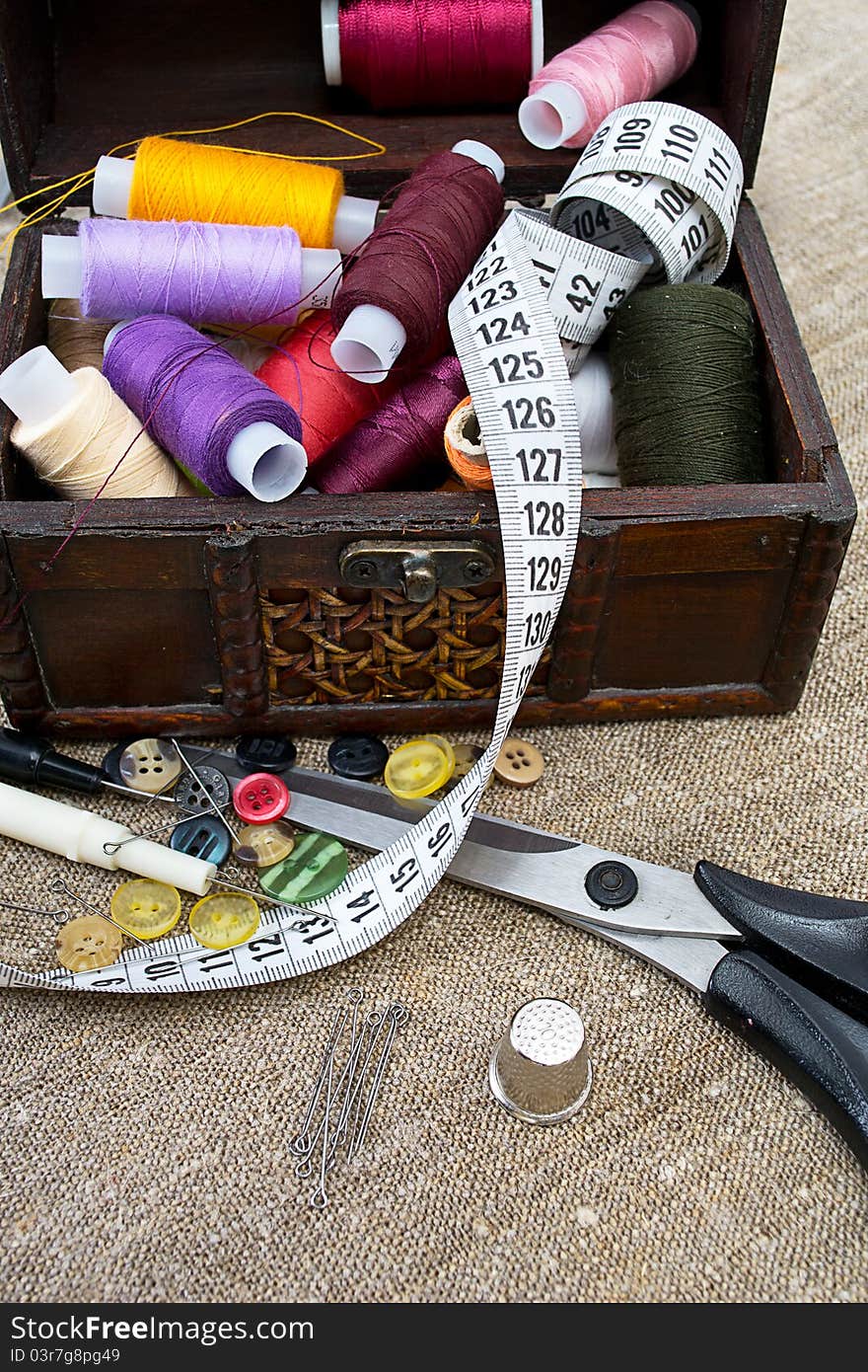 Different sewing supplies: thread, scissors, buttons