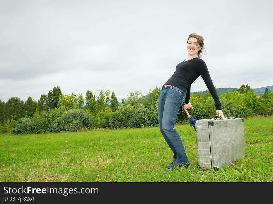 Young woman having fun with a heavy suitcase. Young woman having fun with a heavy suitcase