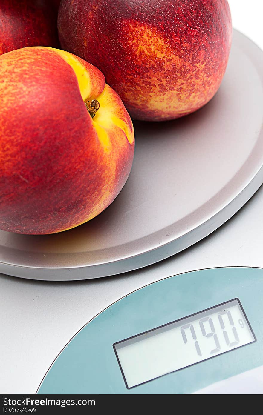 Peaches on the scales on a white background