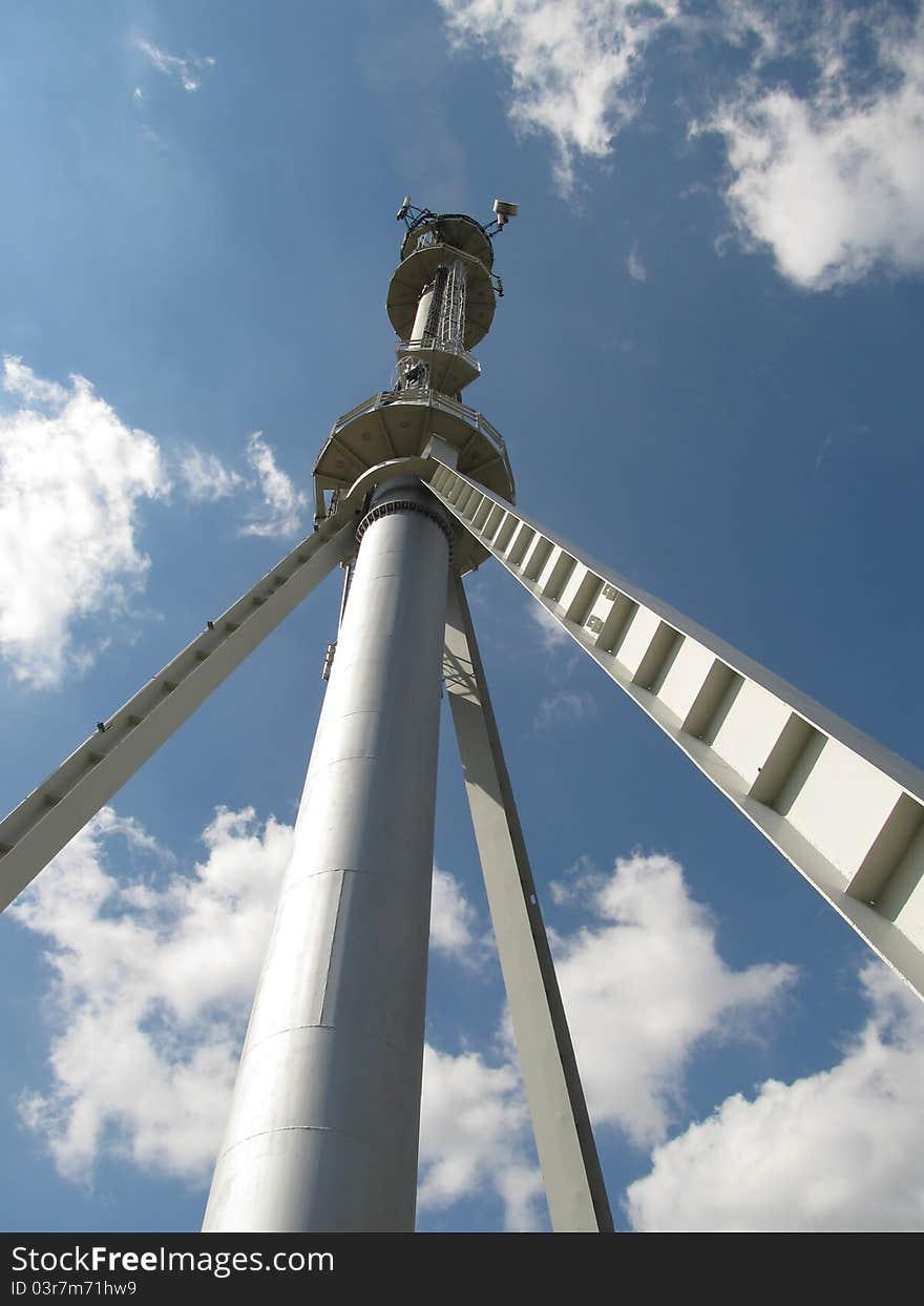 Metal chimney with antennas on the background of blue sky