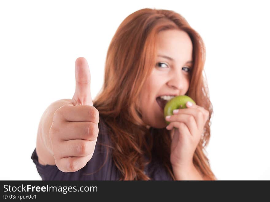 Young woman with green apple and showing thumb up, isolated over white