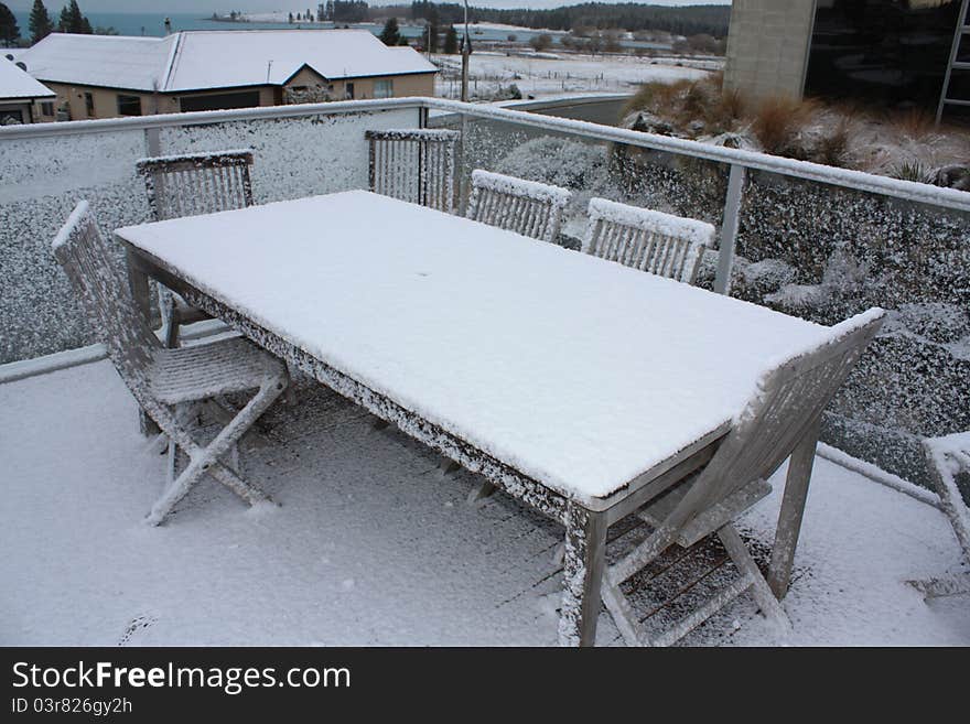 Snow On Wooden Table And Chairs