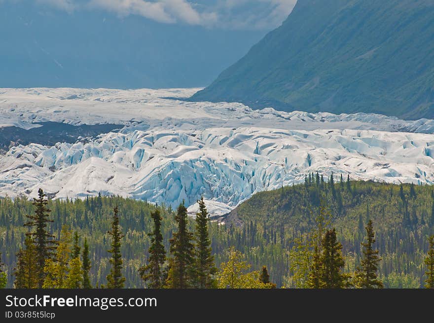 Closeup shot of majestic glacier stretching over mountain valley displaying the forces of nature. Closeup shot of majestic glacier stretching over mountain valley displaying the forces of nature.