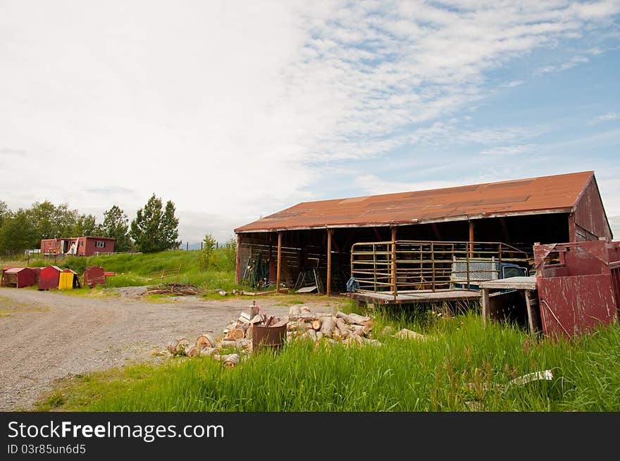 Deserted farm house in the wilderness with cut tree logs.