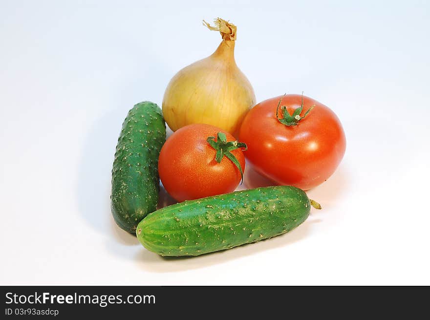 An onion, couple of tomatos and cucumbers. An onion, couple of tomatos and cucumbers