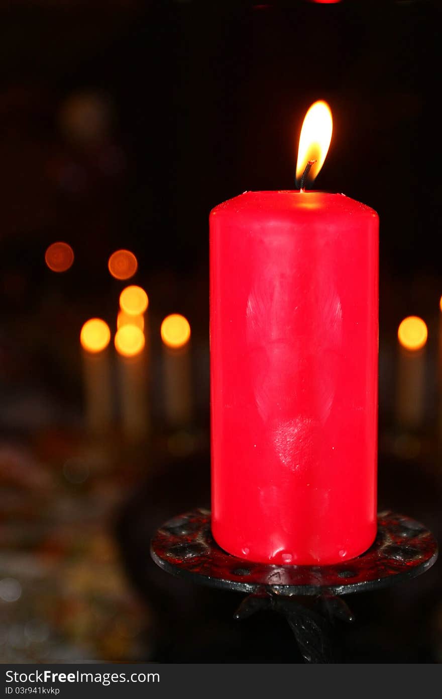 The image of a burning candle under the blurred background