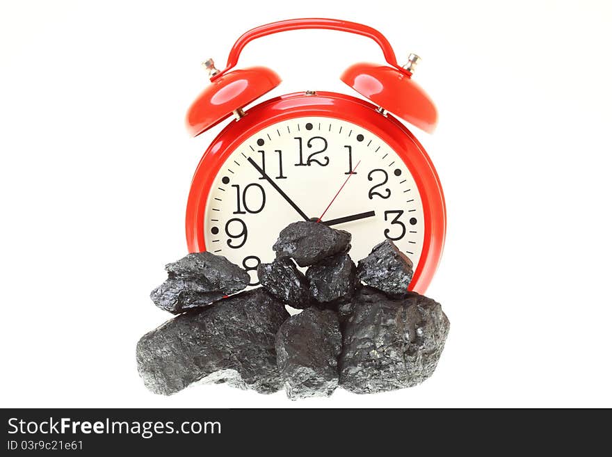 Pieces of coal and red clock isolated on white background. Pieces of coal and red clock isolated on white background