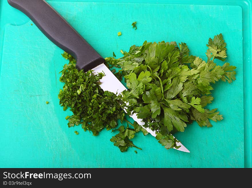 Twig of parsley and kitchen knife nature food texture background. Twig of parsley and kitchen knife nature food texture background