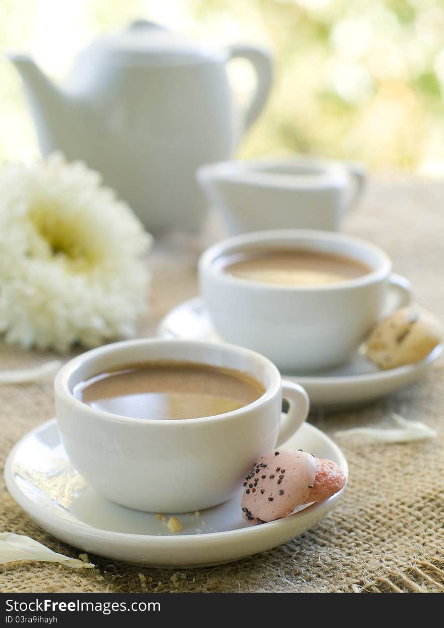 Fresh coffee with milk in cup with cookie close up. Selective focus