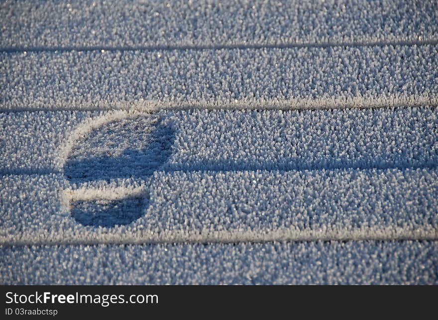 Footprint on the icy walkway. Footprint on the icy walkway