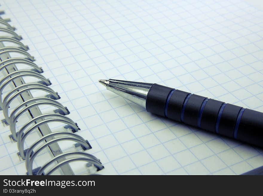 The pen on a notebook in a cage. The pen on a notebook in a cage