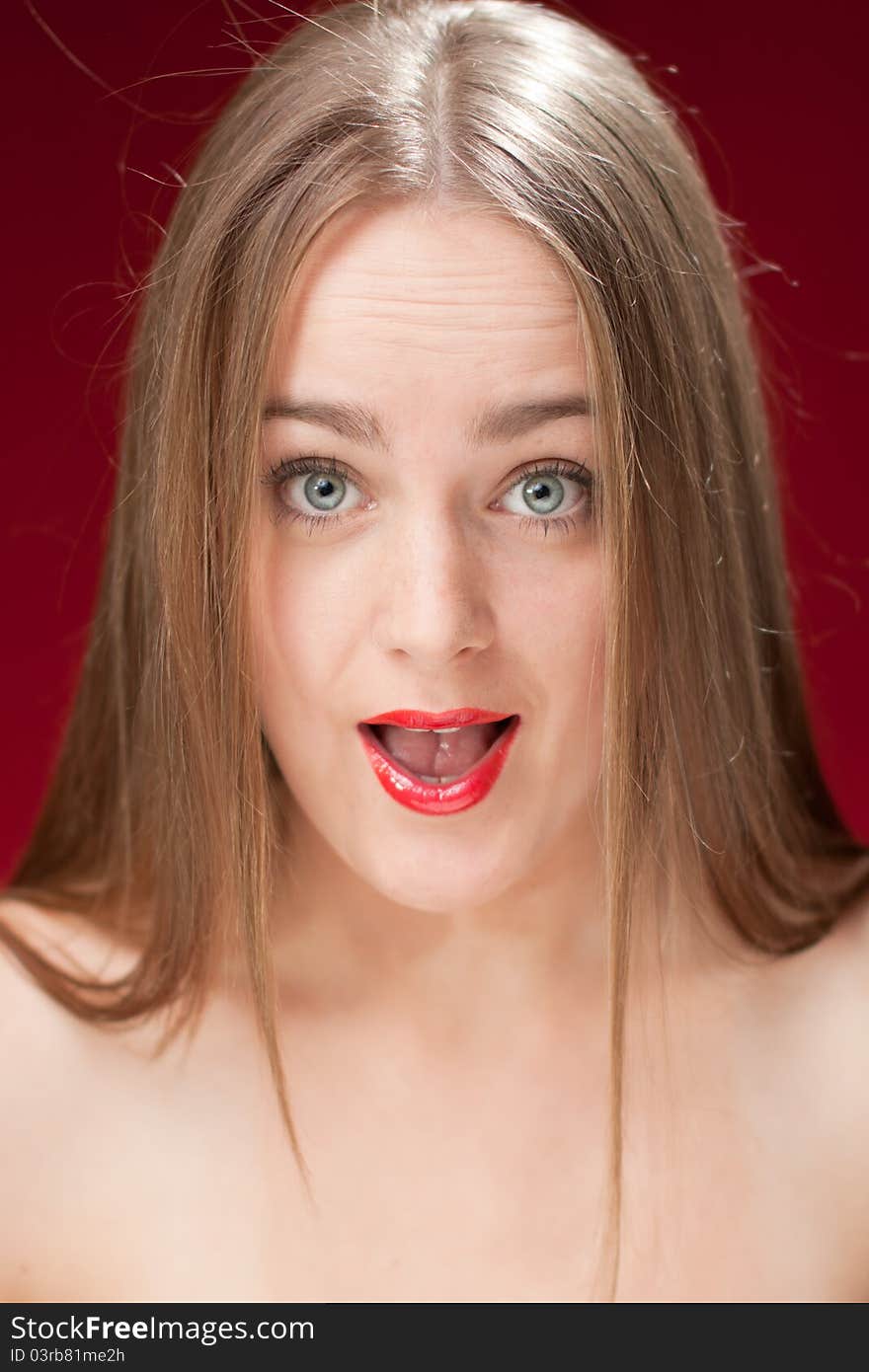 Good looking woman with surprised expression on red background. Good looking woman with surprised expression on red background