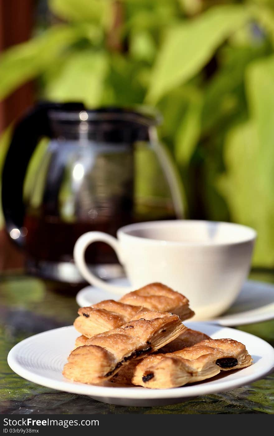 Tea Break table arrangement with raisin pie biscuits and a cup of tea served under a warm tone of afternoon light. Tea Break table arrangement with raisin pie biscuits and a cup of tea served under a warm tone of afternoon light