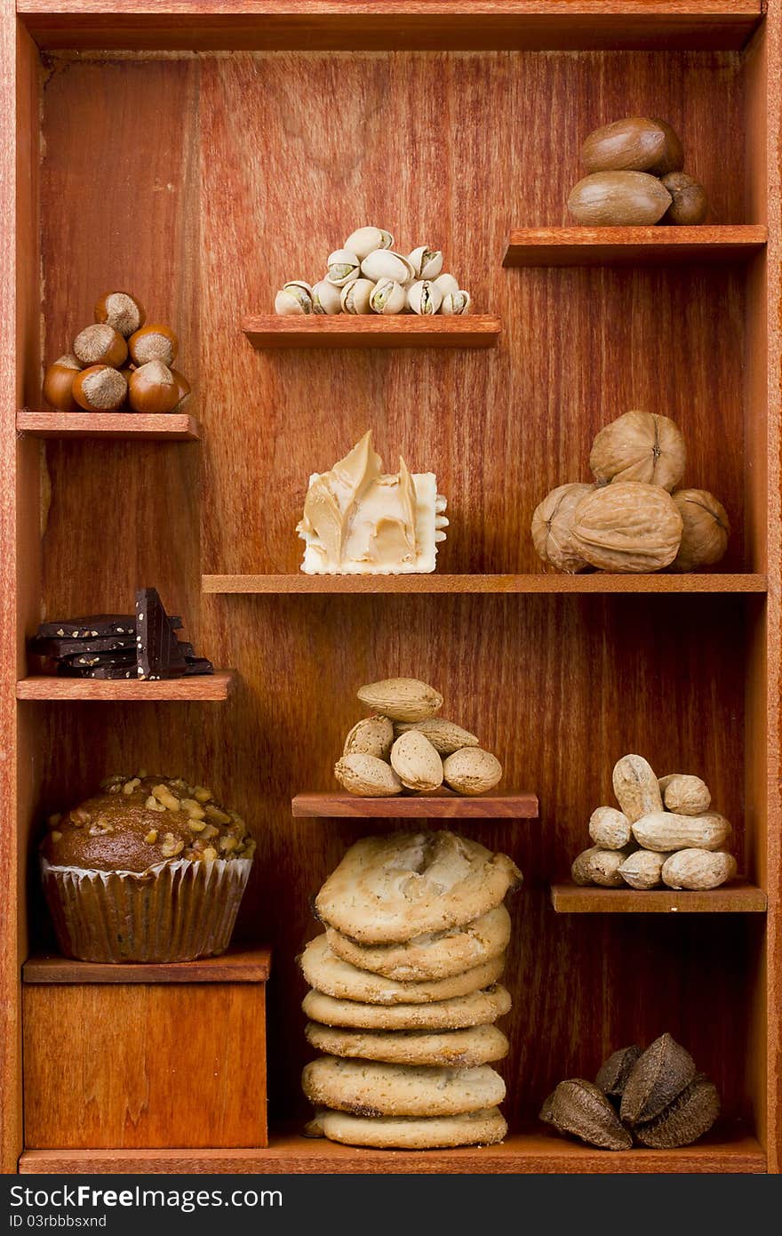 Assortment of different nuts and foods with nuts in them in a wooden shelf. Assortment of different nuts and foods with nuts in them in a wooden shelf.