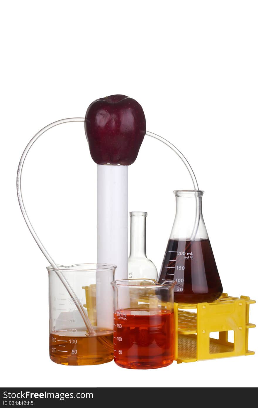 Red apple with transparent tubes leading to scientific beakers and flasks on a white background. Red apple with transparent tubes leading to scientific beakers and flasks on a white background.