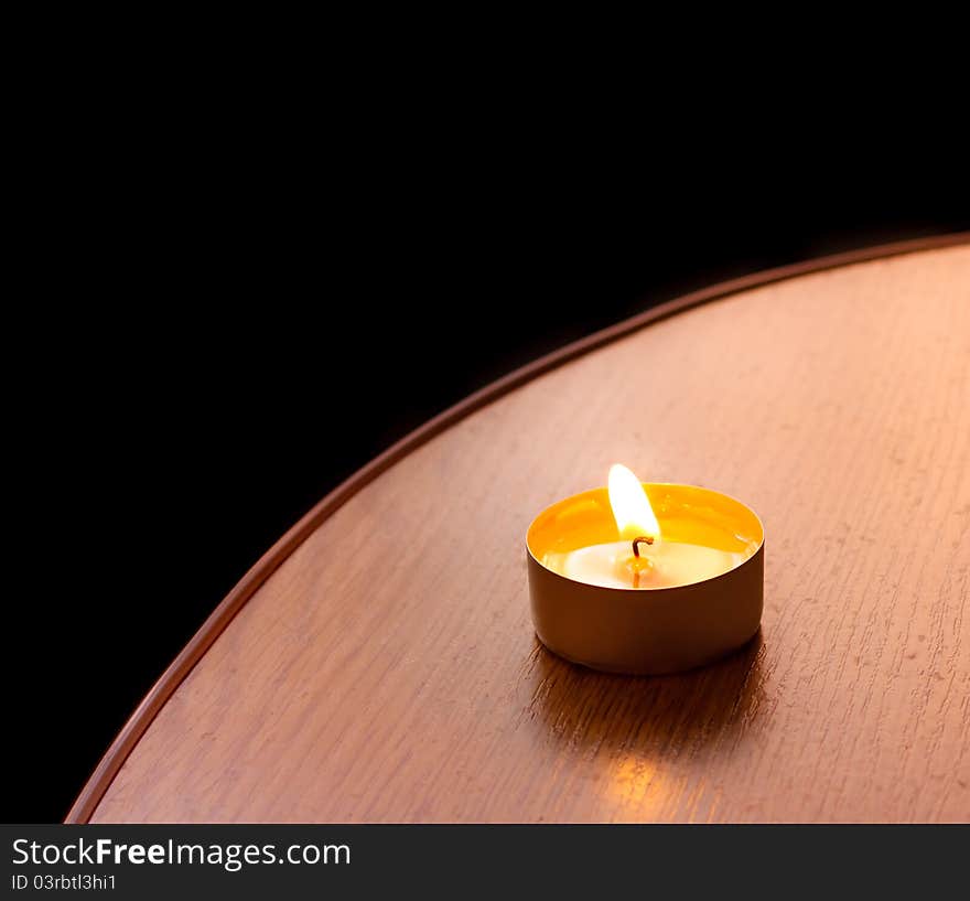 Closeup of burning candle on table