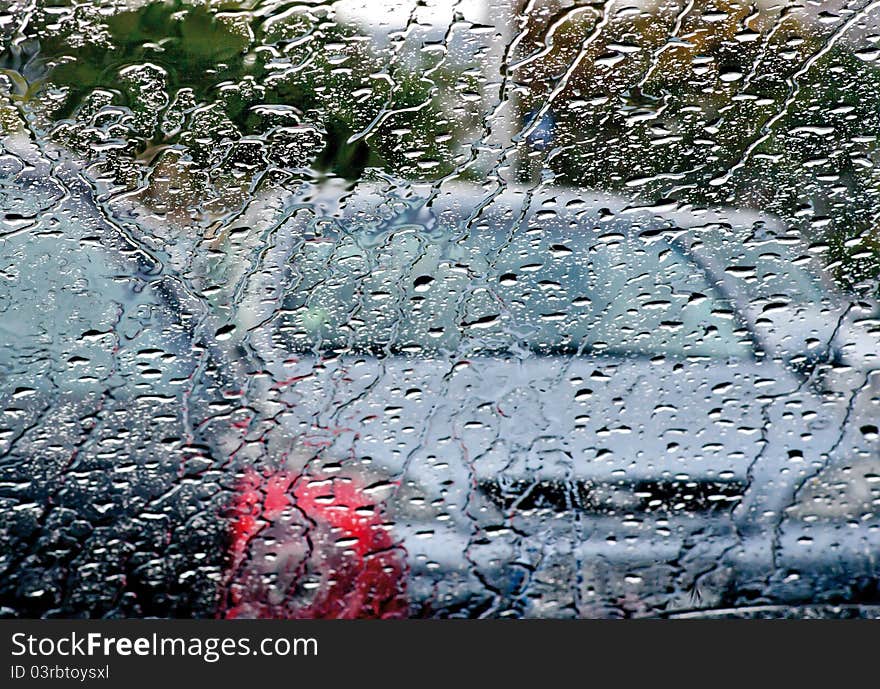 Photo of cars in the rain across the windshield. Photo of cars in the rain across the windshield.